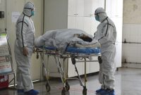 Medical workers in protective suits move a coronavirus patient into an isolation ward at the Second People's Hospital in Fuyang in central China's Anhui Province, Saturday, Feb. 1, 2020. The death toll in China's virus outbreak rose to 259 on Saturday and Beijing criticized Washington's tightening of travel controls to bar most foreign nationals who visited the country within the past two weeks. (Chinatopix via AP)